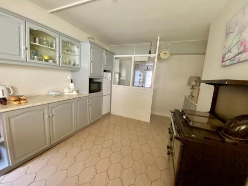 una cocina con armarios blancos y fogones. en Canice Mooney Self Catering Holiday Home en Drumshanbo