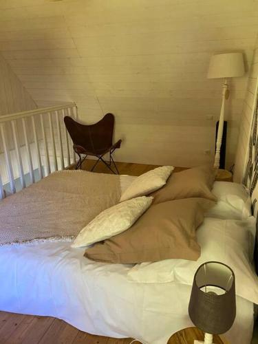 a bed with pillows and a chair in a room at Appartement en campagne in Berville-sur-Mer