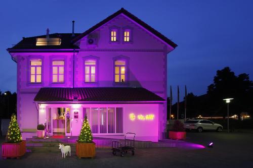 a purple house with a dog in front of it at Hotel Villa Will in Hannover