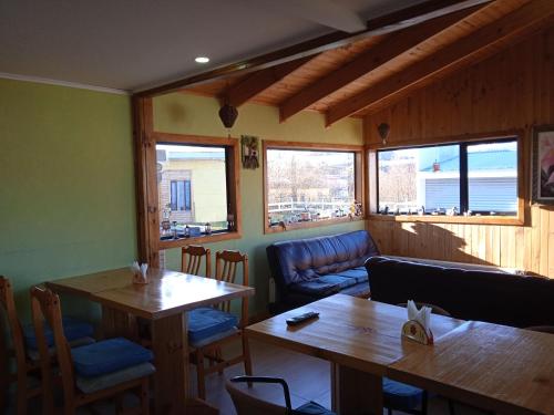 a restaurant with two tables and a couch at Hostal JC in Puerto Natales