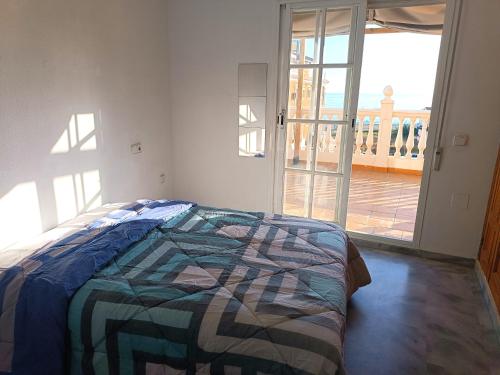 a bedroom with a bed and a door to a balcony at LOVELY PENTHOUSE in front of the beach with free parking in Málaga