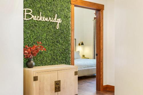 a room with a green wall with a vase on a table at Penthouse in One Ski Hill in Breckenridge