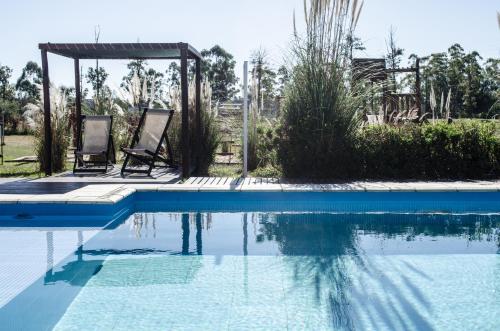 two chairs sitting next to a swimming pool at Amanzi Termal Rental in Concordia