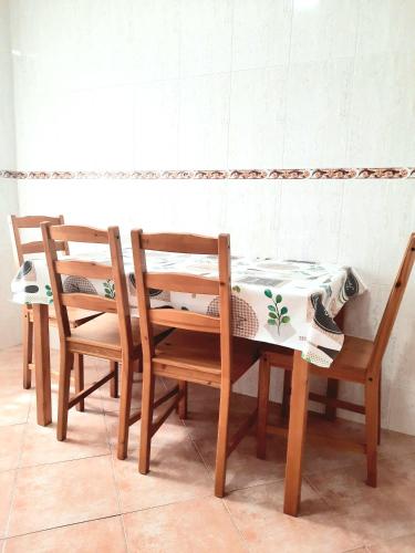 three wooden chairs and a table with a table at Apartamento Obao in Ribadeo