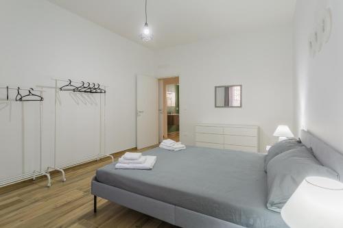 a white bedroom with a bed with two towels on it at CASA di VALE BnB, Box,patio, a 9 min airport,Beach in Bitonto
