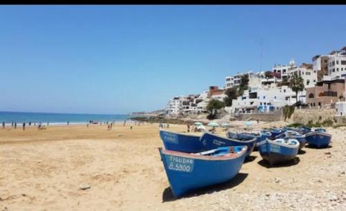 un grupo de barcos azules sentados en una playa en Sidi rahal chat, en Sidi Rahal