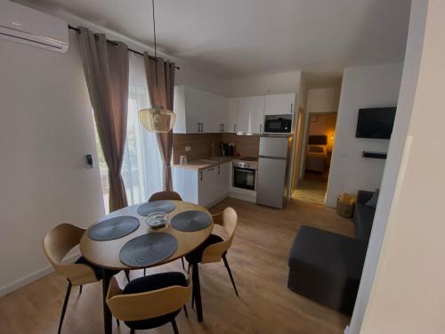 una cucina e un tavolo con sedie in camera di Apartman "Borićevac" a Sinj (Signo)