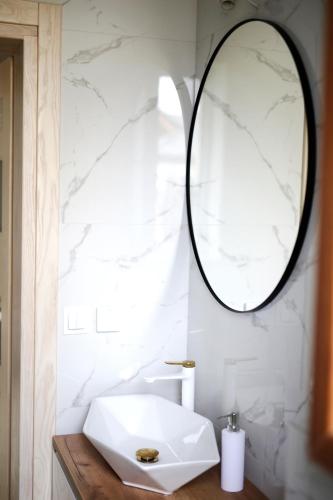 a bathroom with a white sink and a mirror at Zakątek Relaksu in Kamienica Królewska