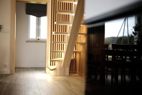 a living room with a staircase leading to a dining room at Zakątek Relaksu in Kamienica Królewska