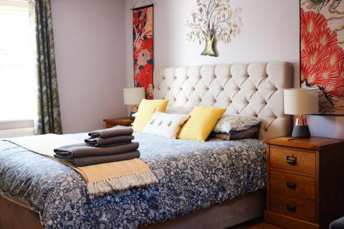 1 dormitorio con 1 cama con cabezal de mechón insertado en Little Lodge on the Yorkshire Wolds en York