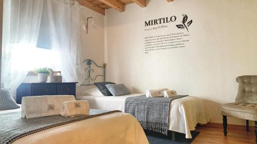 a bedroom with two beds and a chair at Quinta Vale Salgueiro in Seia