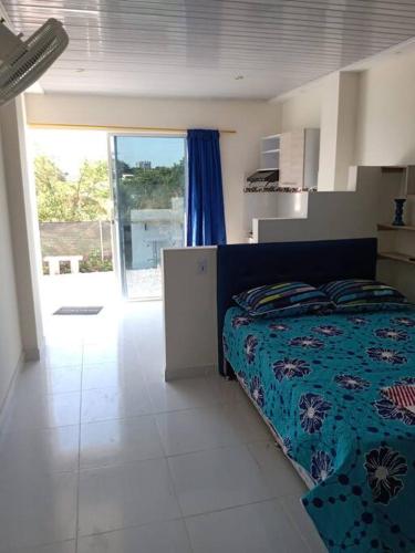 um quarto com uma cama com um edredão azul em Aparta estudio 3 em Santa Marta