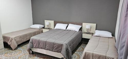 um quarto com duas camas e duas mesas com candeeiros em Complejo Llay em La Rioja