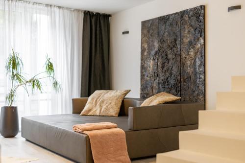 a living room with a couch and a large window at BNB SK Zámocká Artist Apartment in Bratislava