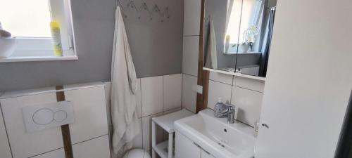 uma casa de banho branca com um lavatório e um WC em Private Apartment em Langenhagen