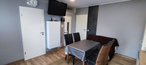 uma sala de jantar com mesa e cadeiras e uma televisão em Private Apartment em Langenhagen