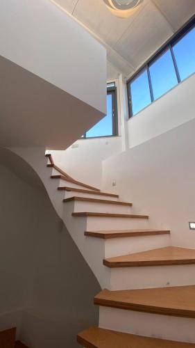 a staircase in a house with white walls and windows at Urla Casa Bianca in Urla