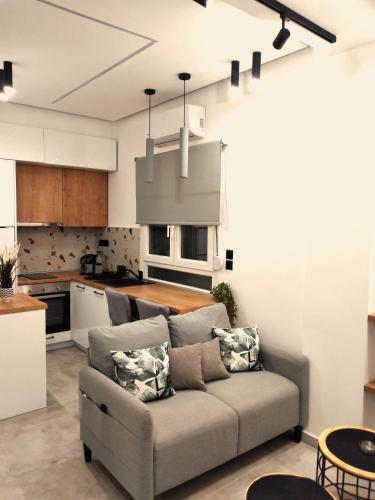 ein Wohnzimmer mit einem Sofa und einer Küche in der Unterkunft Modi Stay in Thessaloniki