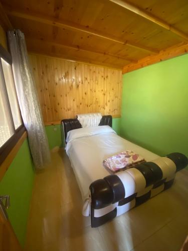 1 dormitorio con 1 cama en una habitación con paredes verdes en Peñon de velez de la gomera, en Alhucemas