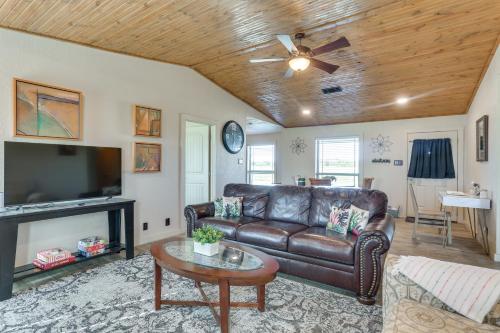 a living room with a leather couch and a tv at Ranch Getaway with Pool and Horse Stall Access! in Calera