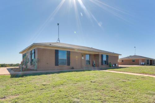 a brick house with the sun in the sky at Ranch Getaway with Pool and Horse Stall Access! in Calera