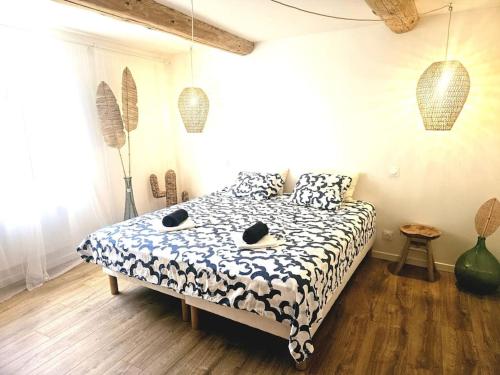 蒙布舍叙尔雅布龙Le gîte de la marquise - Elégant appartement avec terrasse -的卧室里有一张床，床铺是黑白相间的棉被