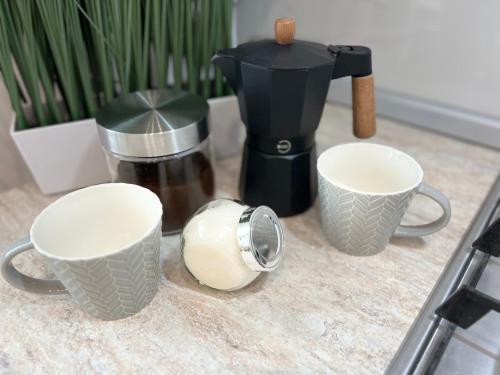 a counter with two cups and a coffee maker at Atmosfera Sibiu in Sibiu