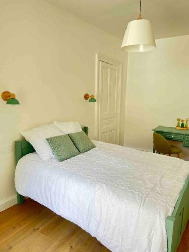 une chambre avec un lit avec des draps blancs et un bureau dans l'établissement Magnifique appartement familiale 6 personnes 3 chambres et 3 salles de bain en hyper centre avec rue piétonne Parking 20m, à Troyes