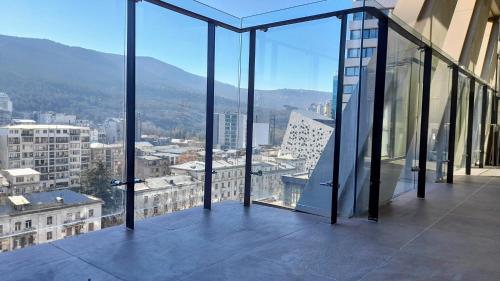 vistas a la ciudad desde un edificio con ventanas de cristal en Smartest Home and Location in Tbilisi Vake, en Tiflis