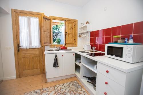 una cucina con banconi bianchi e forno a microonde di Espacio Antares a Icod de los Vinos