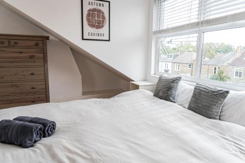 a white bed in a bedroom with a window at Spacious 2 Bedroom Apartment in Hackney in London