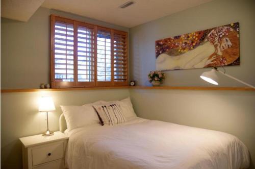 um quarto com uma cama branca e uma janela em OFF CAMPUS UC Room em Calgary
