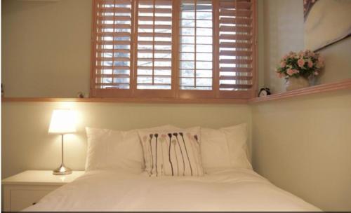 a bedroom with a white bed with a window at OFF CAMPUS UC Room in Calgary