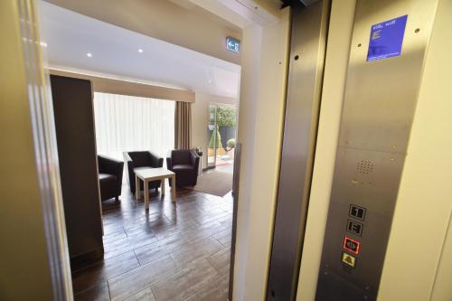 a hallway with a waiting room with chairs and a table at Hotel Villa Will in Hannover