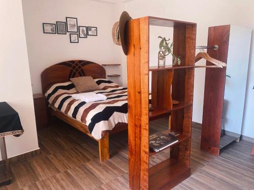 a bedroom with a bed and a book shelf at La Casa de Damien in Urubamba