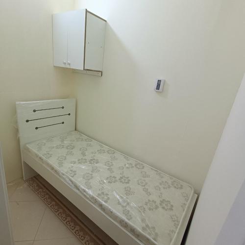 Al Basam Center في دبي: غرفة صغيرة بها سرير وخزانة