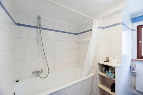 a white bathroom with a tub and a shower at Haugstetter Schwarzwaldhaus in Neubulach