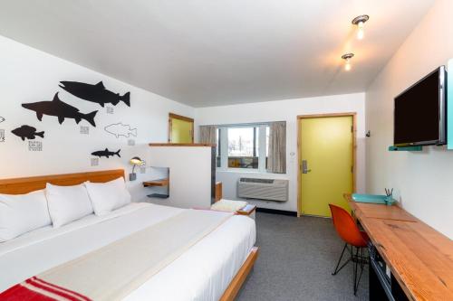 a bedroom with a bed and a flat screen tv at The LARK in Bozeman