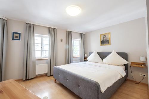 ein Schlafzimmer mit einem großen Bett und zwei Fenstern in der Unterkunft Alte Buchbinderei Apartments in Baden-Baden