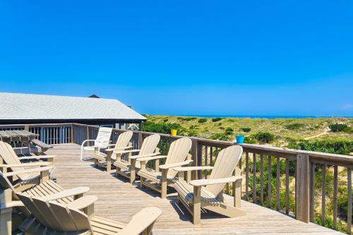 a row of chairs sitting on a wooden deck at Kinnakeet Dunes in Avon