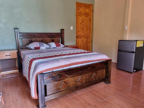 a bedroom with a bed and a small refrigerator at Hotel Gitana Corcovado, y Tour operador in Drake