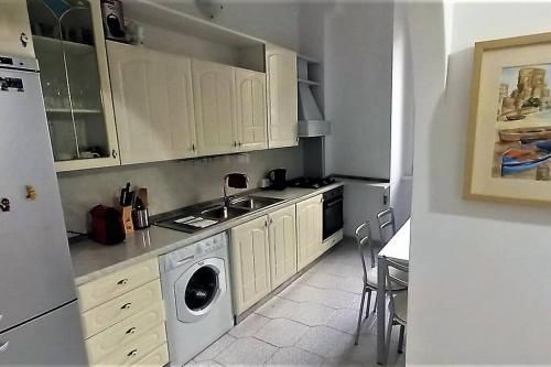 a kitchen with white cabinets and a washing machine at Cozy flat in Testaccio in Rome