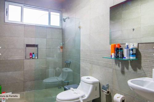 a bathroom with a shower and a toilet and a sink at CASA DE PLAYA AMUEBLADA in Quebrada Ganado