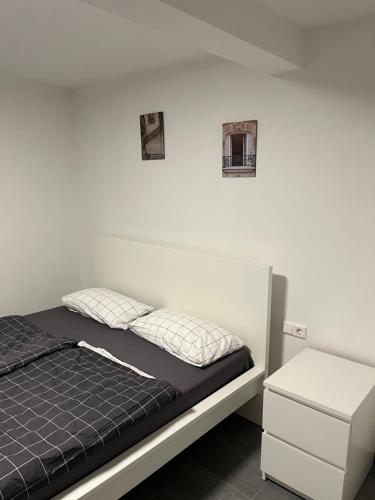 Bett in einem Zimmer mit zwei Bildern an der Wand in der Unterkunft Home-for-you-Ferienwohnung Monteurwohnung in Buchen