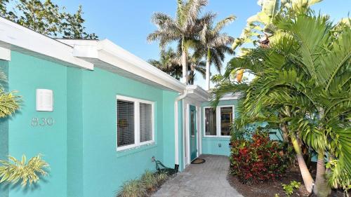 ein blaues Haus mit Palmen davor in der Unterkunft Seascapes Home in Anna Maria