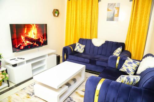- un salon avec des canapés bleus et une cheminée dans l'établissement My Cozy Home By BC, à Nairobi