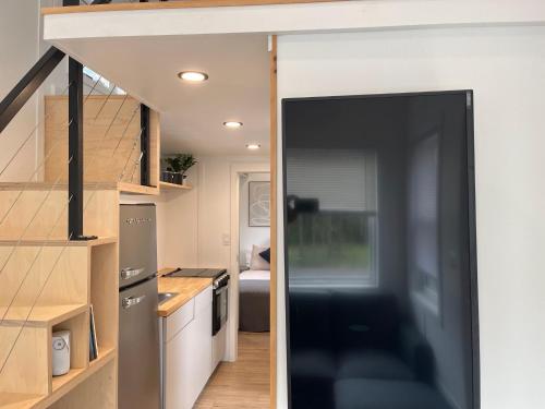 a small kitchen with a sliding door leading into a tiny house at The Mockingbird Tiny Home in Perry