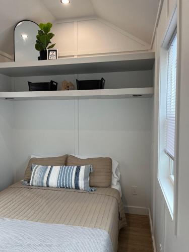 a small bedroom with a bed and a window at The Sam Tiny Home in Perry