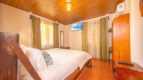 a bedroom with a bed and a dresser and a desk at Cerro Chato's House in Fortuna