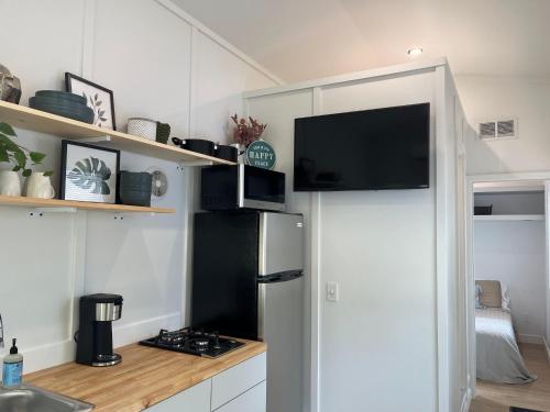 a kitchen with a refrigerator and a flat screen tv at The Sam Tiny Home in Perry